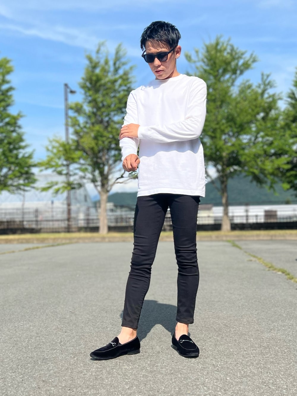 ホワイト系のTシャツ/カットソー、ブラック系のデニムパンツ、ブラック系のローファーを着用したメンズの夏コーディネートの2枚目の写真