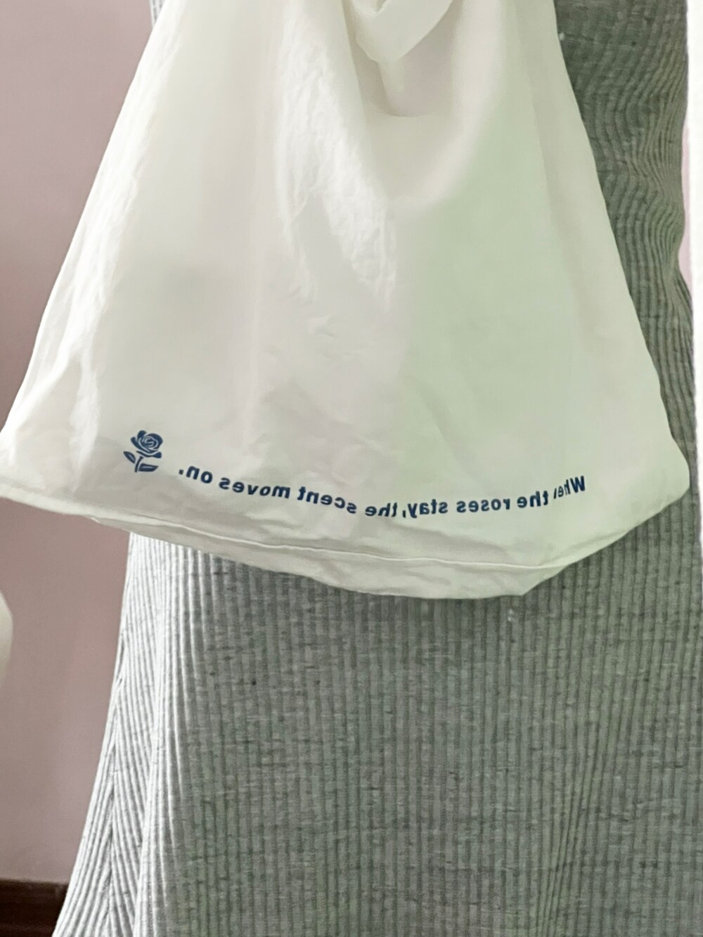 グレー系のワンピース、ホワイト系のショルダーバッグを着用したレディースの春コーディネートの2枚目の写真