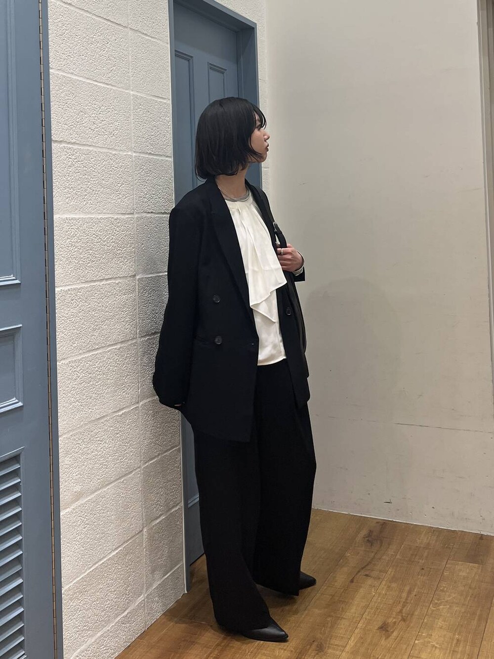 ブラック系のショルダーバッグ、ブラック系のブーツ、ホワイト系のシャツ/ブラウスを着用したレディースの冬コーディネートの2枚目の写真