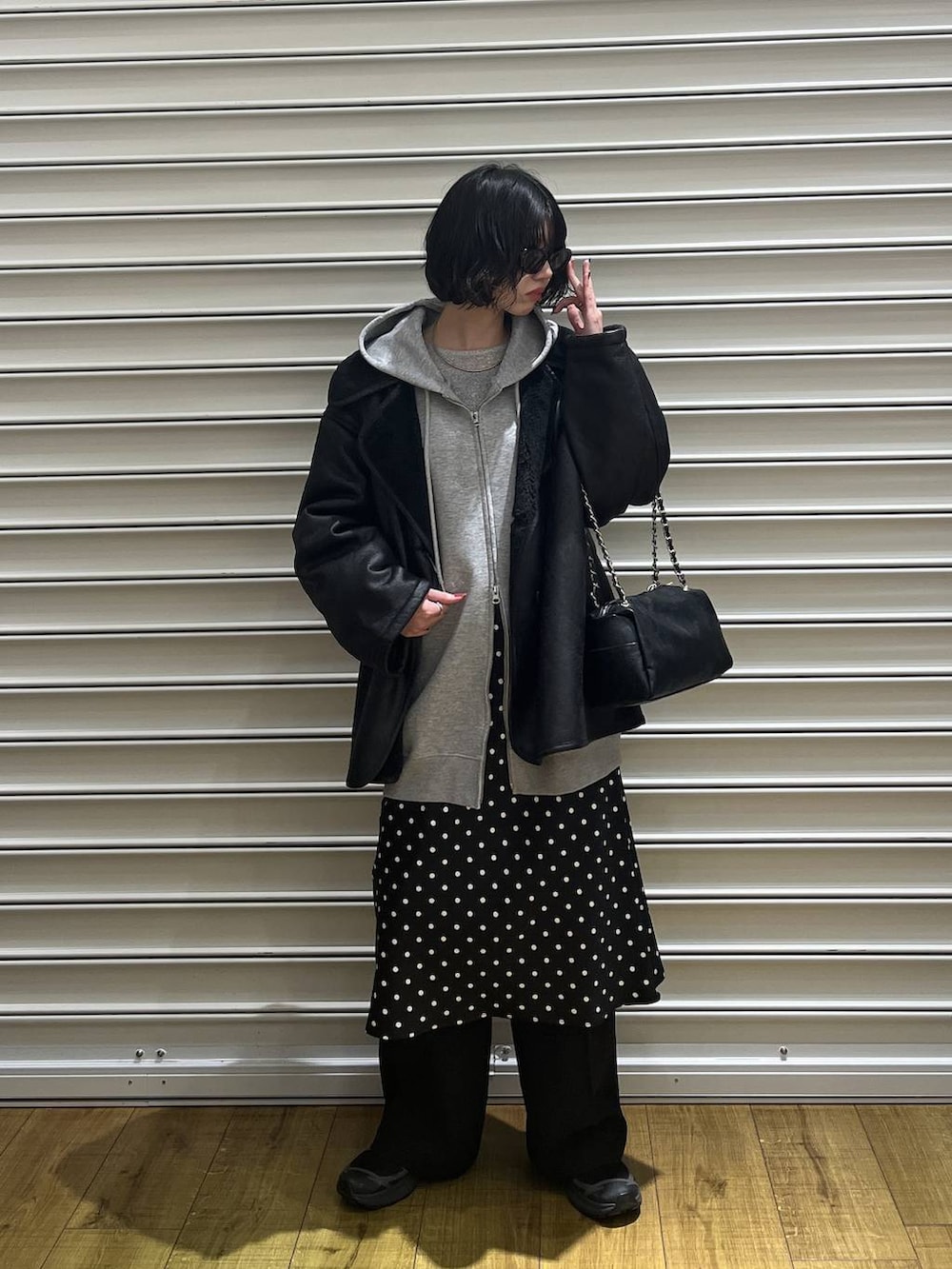 ブラック系のスカート、グレー系のパーカー、ブラック系のムートンコートを着用したレディースの冬コーディネートの2枚目の写真