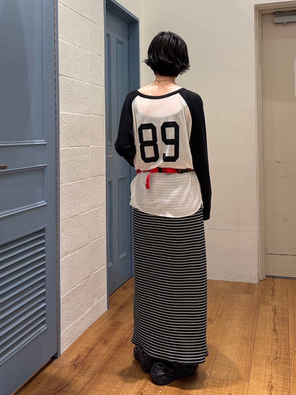 ホワイト系のTシャツ/カットソー、レッド系のボディバッグ/ウエストポーチ、ブラック系のスカートを着用したレディースの夏コーディネートの2枚目の写真