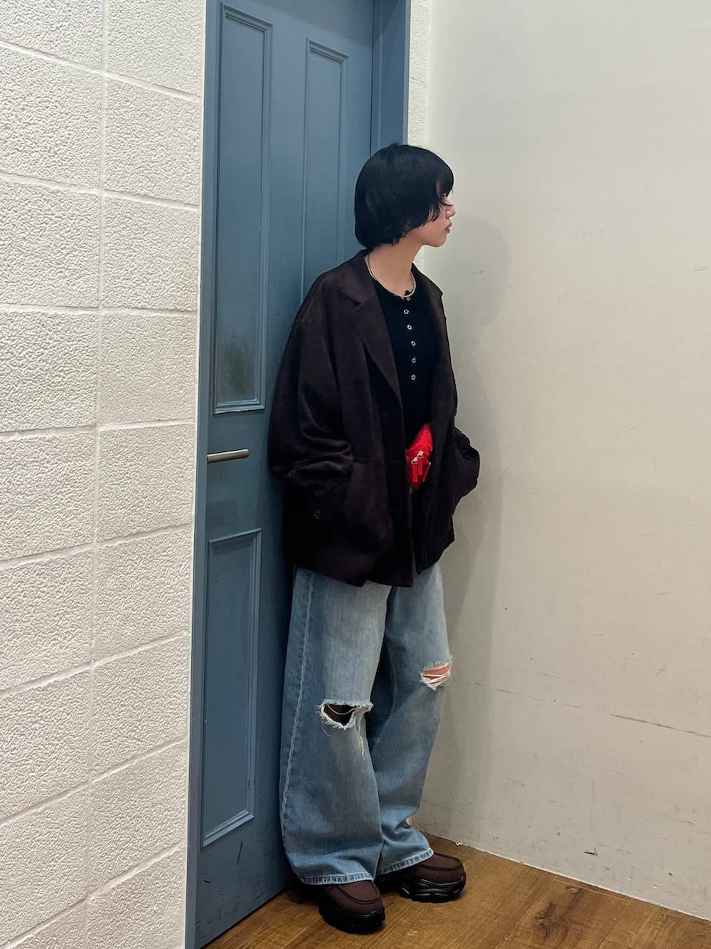 ブラック系のニット/セーター、ブルー系のデニムパンツ、ブラウン系のローファーを着用したレディースの春コーディネートの4枚目の写真