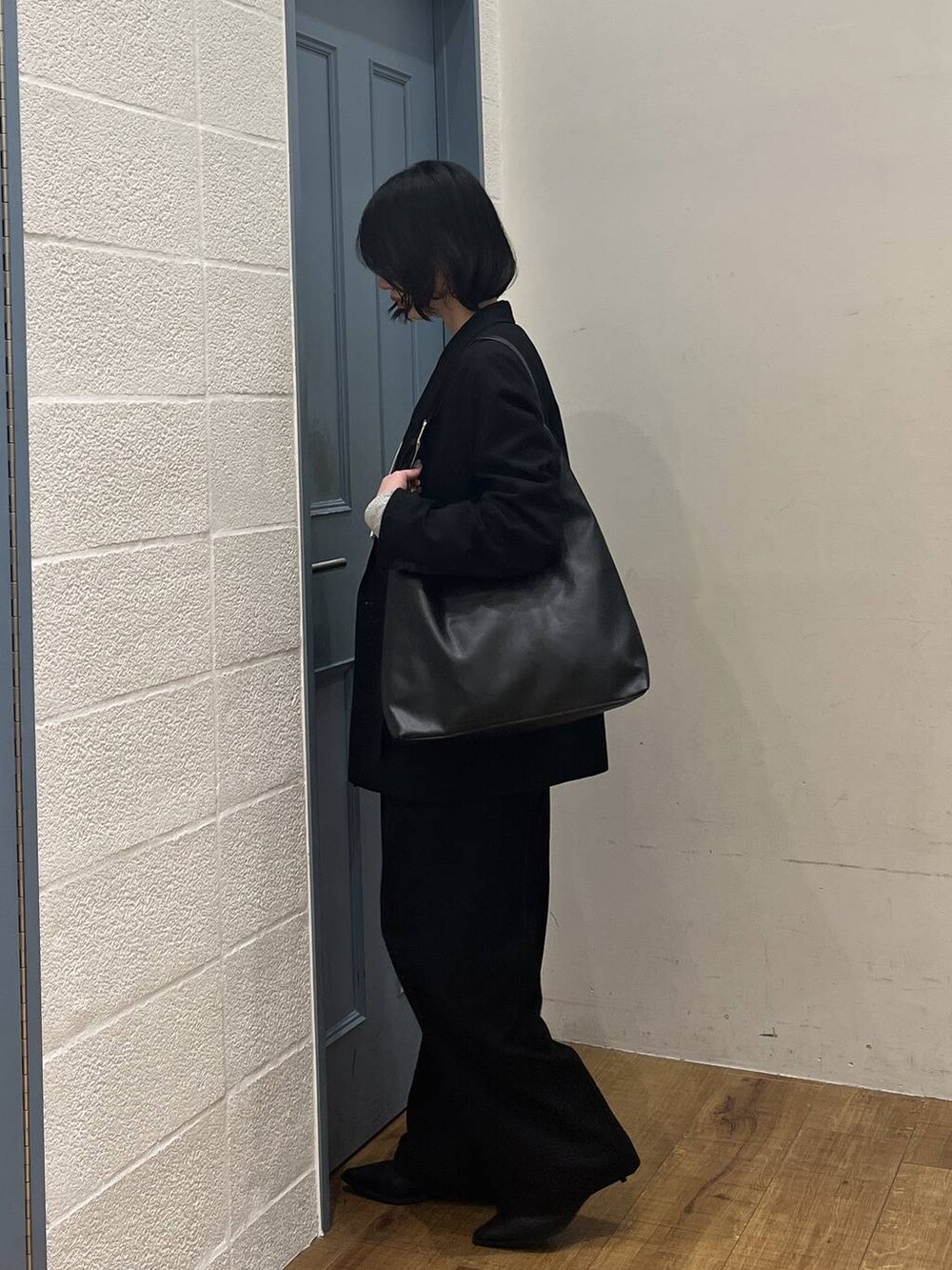 ブラック系のショルダーバッグ、ブラック系のブーツ、ホワイト系のシャツ/ブラウスを着用したレディースの冬コーディネートの3枚目の写真