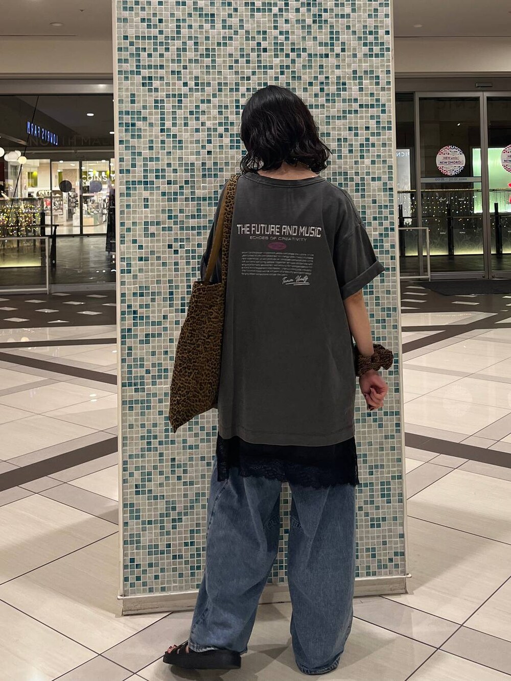 ブラック系のサンダル、その他のトートバッグ、ブルー系のデニムパンツを着用したレディースの夏コーディネートの3枚目の写真