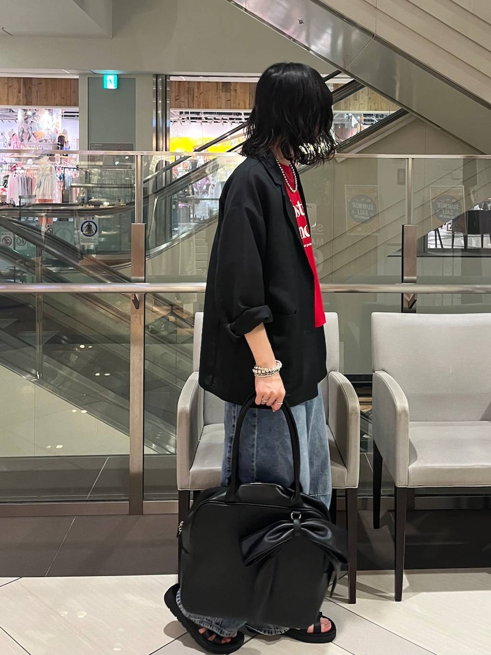 ブラック系のサンダル、ブルー系のデニムパンツ、レッド系のTシャツ/カットソーを着用したレディースの夏コーディネートの2枚目の写真