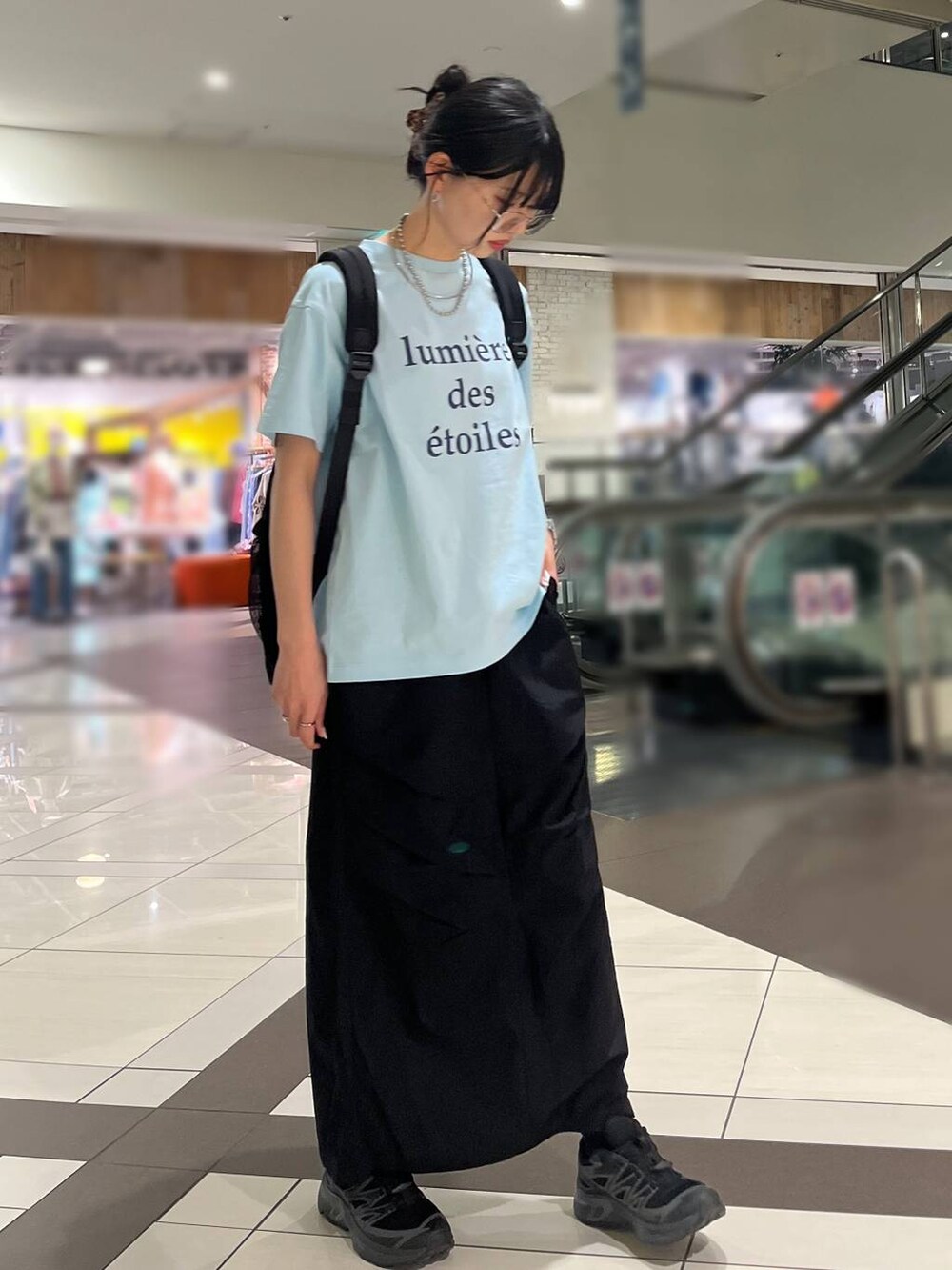 ブルー系のTシャツ/カットソー、ブラック系のバックパック/リュック、ブラック系のスカートを着用したレディースの春コーディネートの3枚目の写真