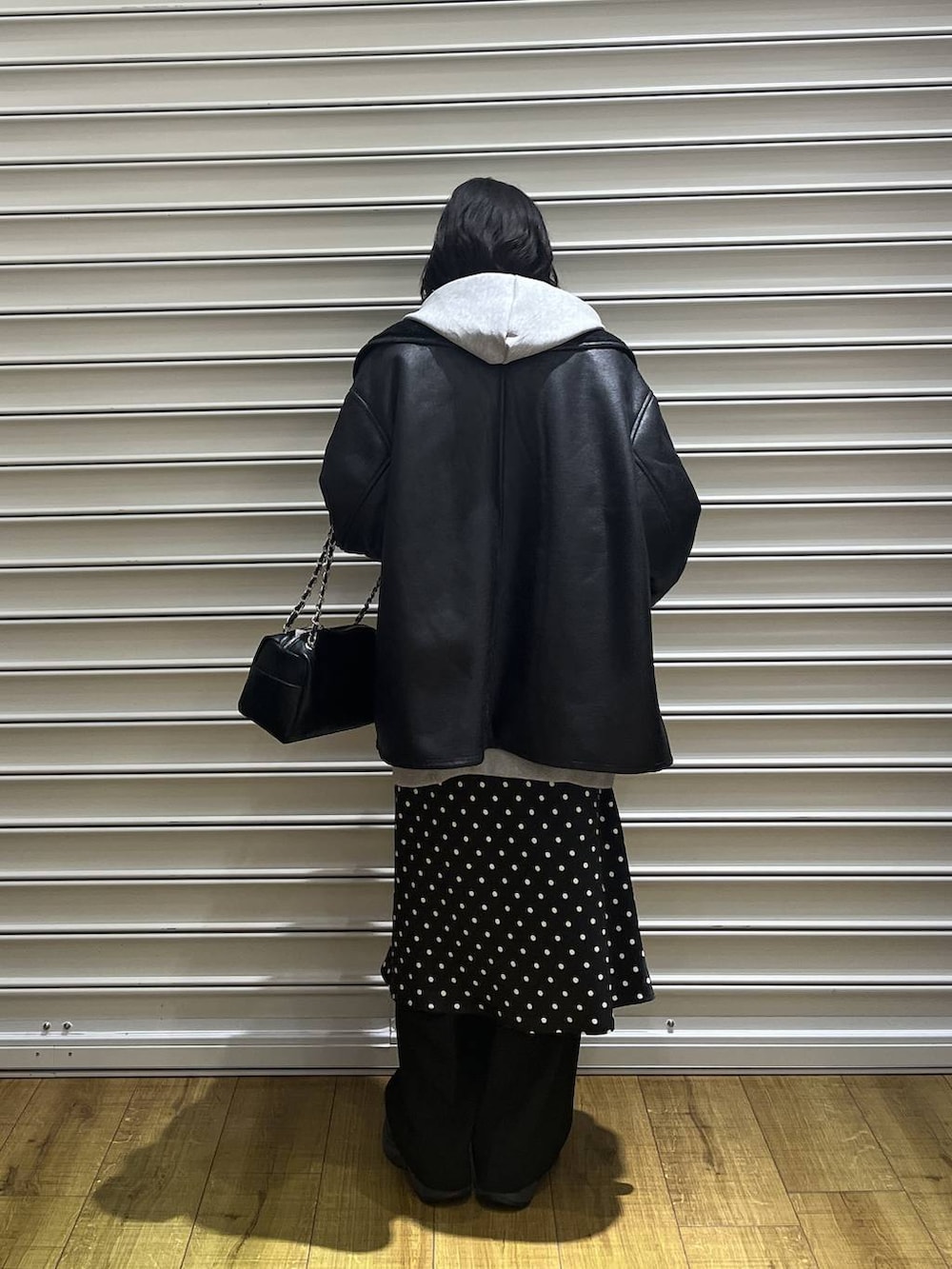 ブラック系のスカート、グレー系のパーカー、ブラック系のムートンコートを着用したレディースの冬コーディネートの3枚目の写真