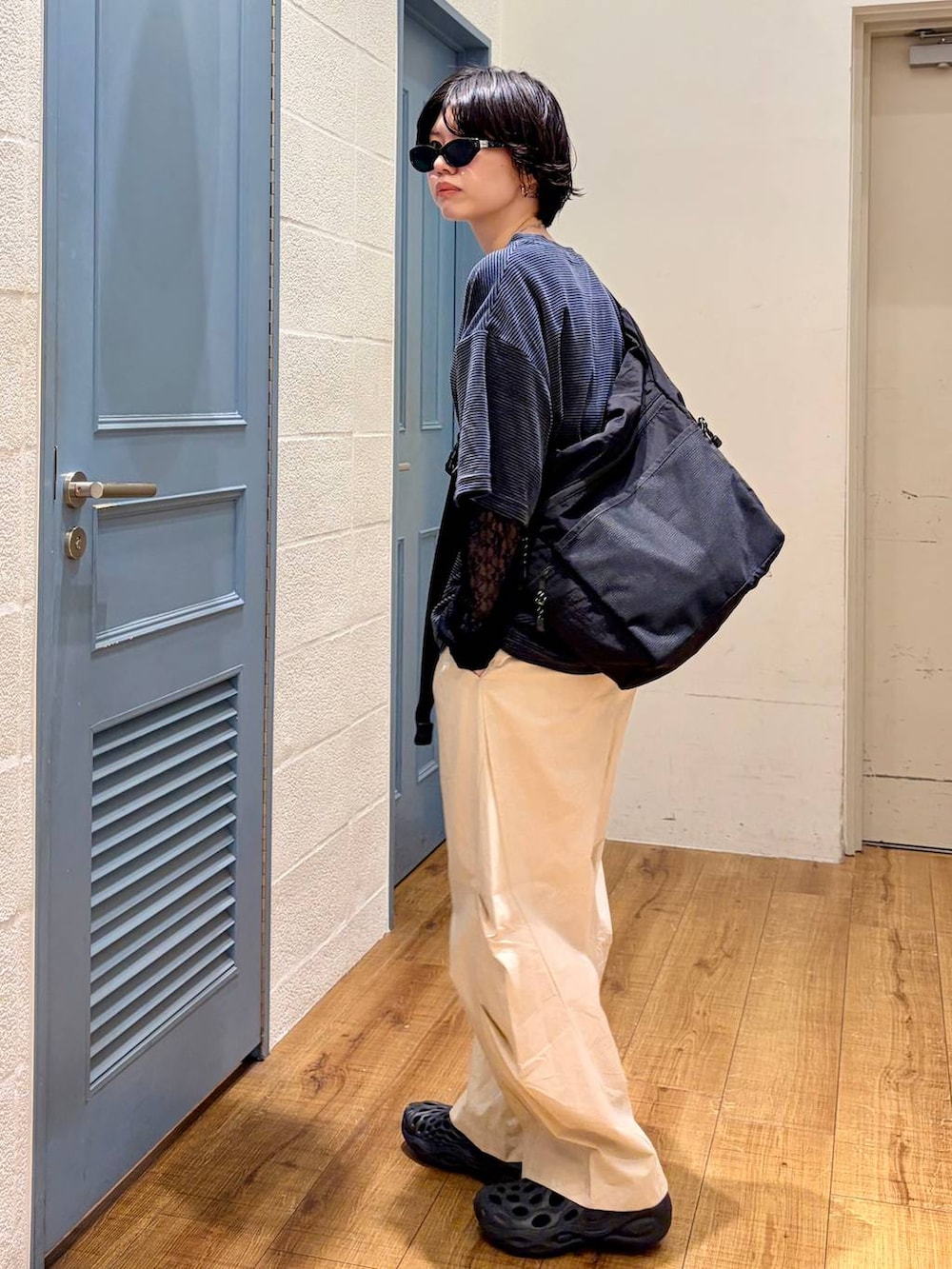 ブラック系のショルダーバッグ、ベージュ系のその他パンツ、グリーン系のTシャツ/カットソーを着用したレディースの夏コーディネートの2枚目の写真