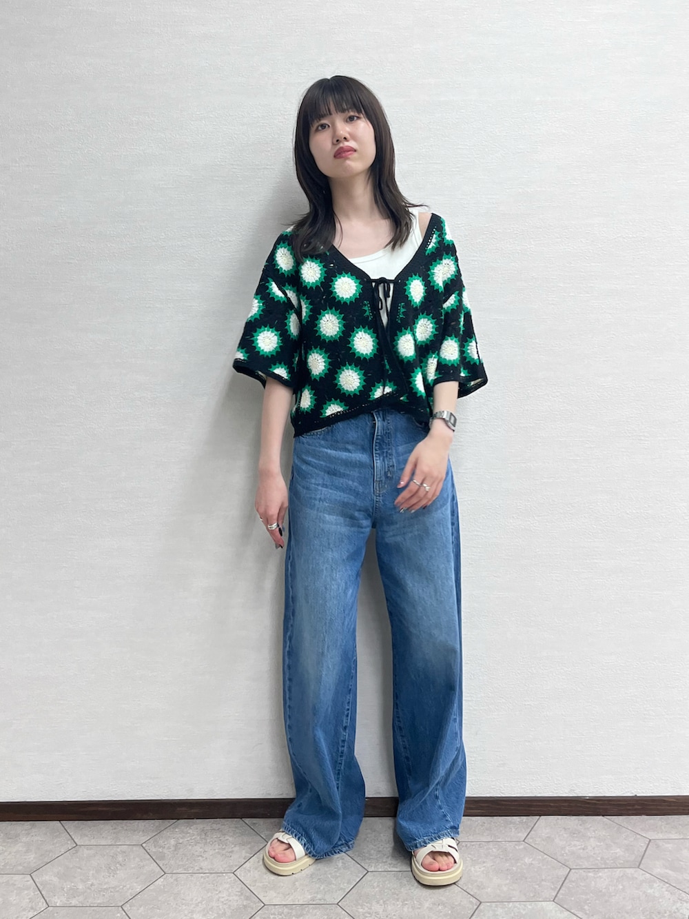 ブラック系のカーディガン/ボレロ、ブルー系のデニムパンツ、ホワイト系のシューズを着用したレディースの春コーディネートの3枚目の写真