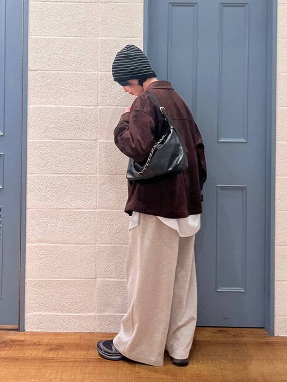 ブラック系のショルダーバッグ、ブラウン系のテーラードジャケット、ブルー系のシャツ/ブラウスを着用したレディースの冬コーディネートの4枚目の写真