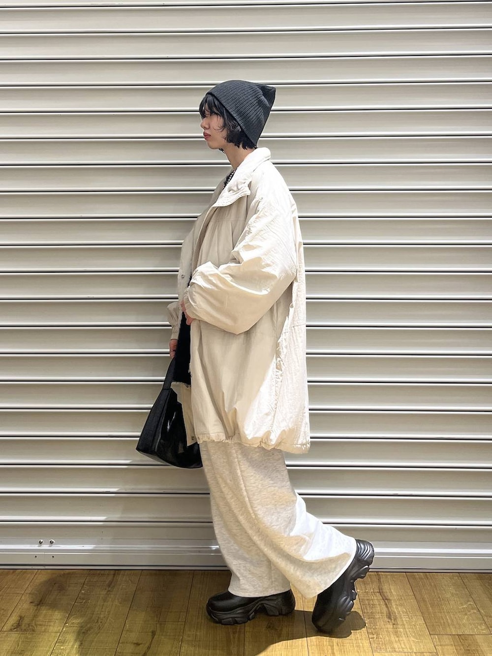 ブラック系のブーツ、グレー系のスウェットパンツ、ブラック系のショルダーバッグを着用したレディースの秋コーディネートの2枚目の写真