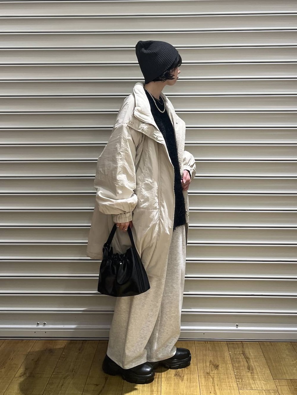 ブラック系のブーツ、グレー系のスウェットパンツ、ブラック系のショルダーバッグを着用したレディースの秋コーディネートの4枚目の写真