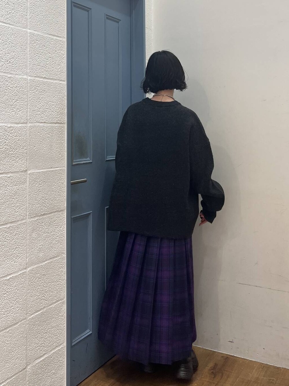 ブラック系のブーツ、パープル系のスカート、グレー系のニット/セーターを着用したレディースの冬コーディネートの2枚目の写真