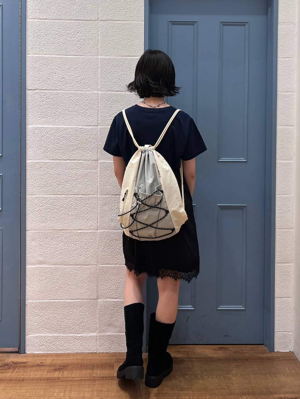 ブラック系のブーツ、ブルー系のTシャツ/カットソー、ホワイト系のバックパック/リュックを着用したレディースの春コーディネートの3枚目の写真