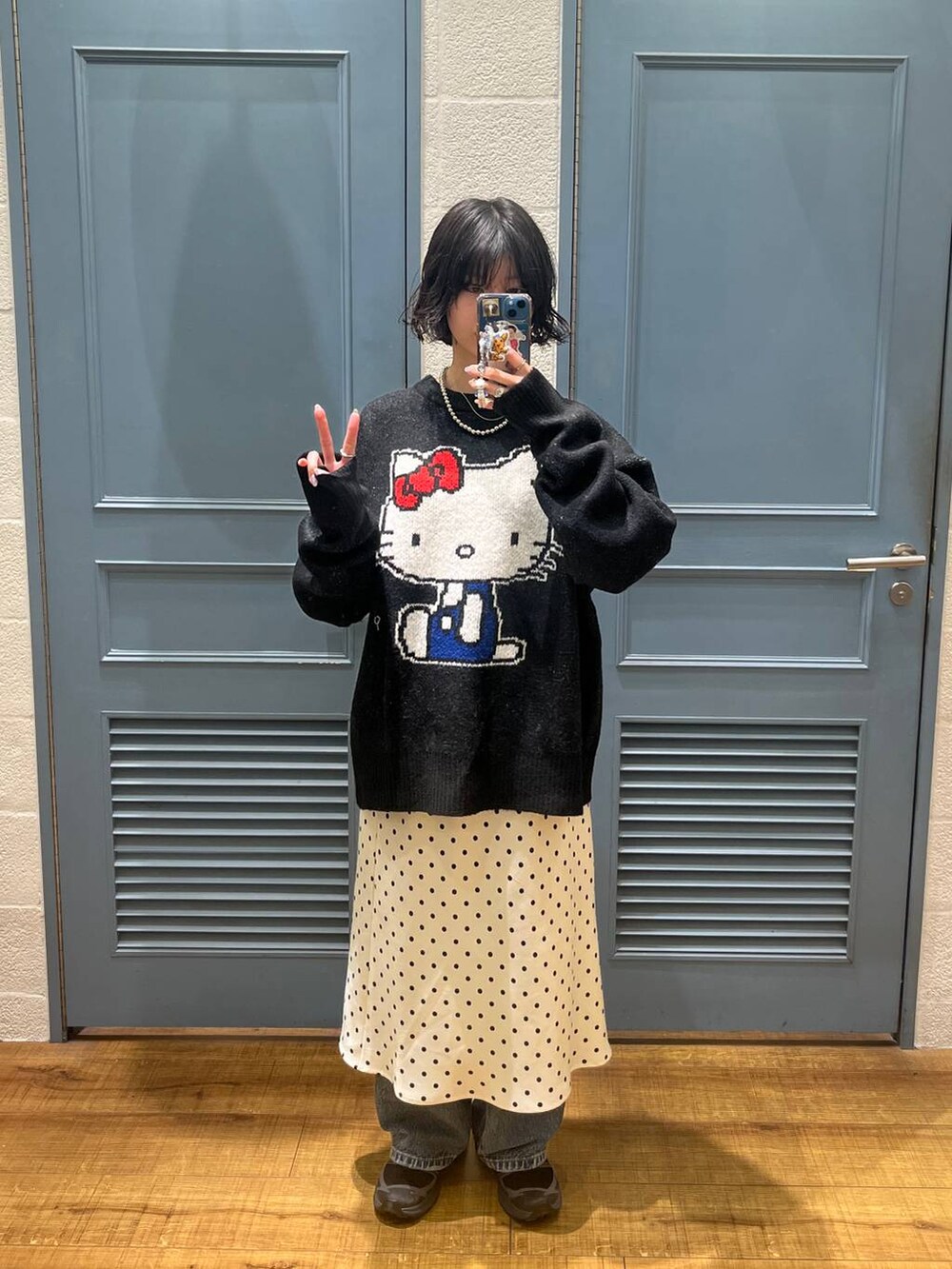 ホワイト系のスカート、ブルー系のデニムパンツ、ブラック系のニット/セーターを着用したレディースの秋コーディネートの3枚目の写真