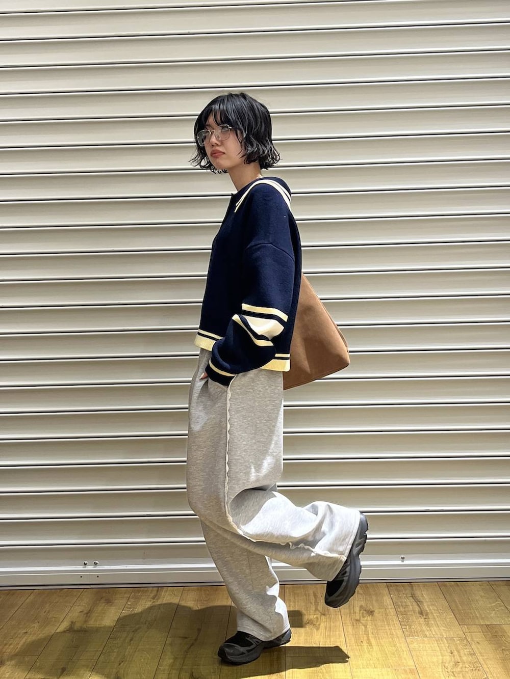 ベージュ系のショルダーバッグ、グレー系のスウェットパンツ、ブルー系のニット/セーターを着用したレディースの冬コーディネートの4枚目の写真