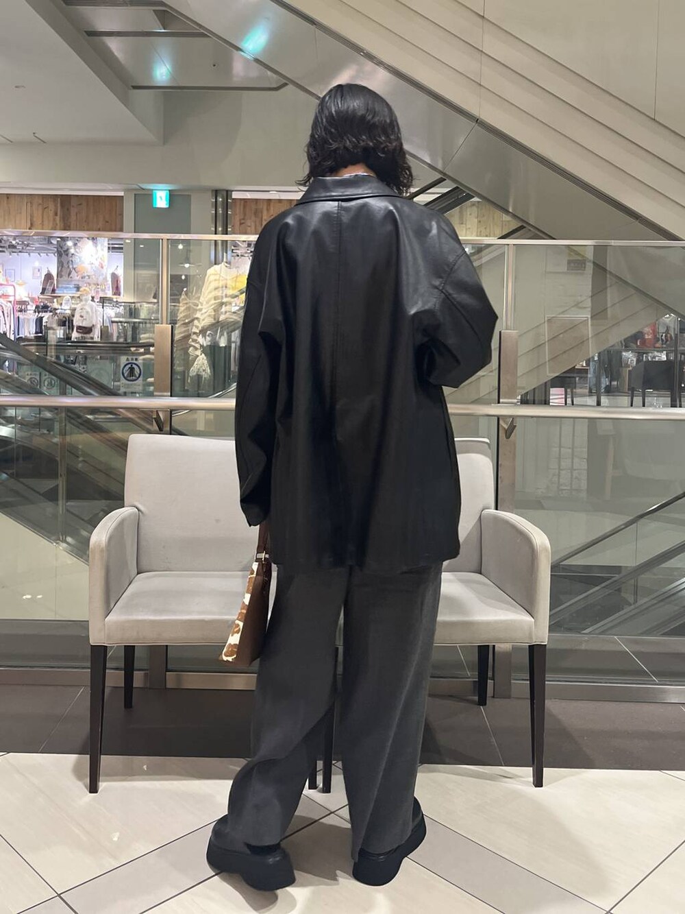 グレー系のサロペット/オーバーオール、ブラック系のサンダル、ブルー系のシャツ/ブラウスを着用したレディースの秋コーディネートの3枚目の写真