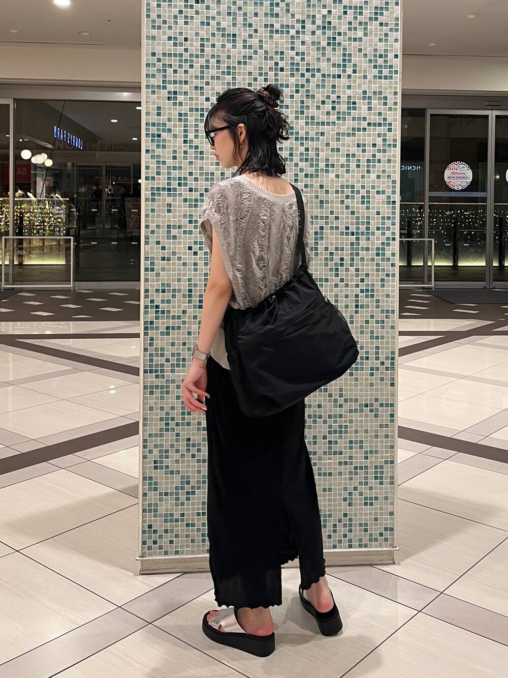 シルバー系のサンダル、ブラック系のショルダーバッグ、ブラック系のスカートを着用したレディースの夏コーディネートの3枚目の写真