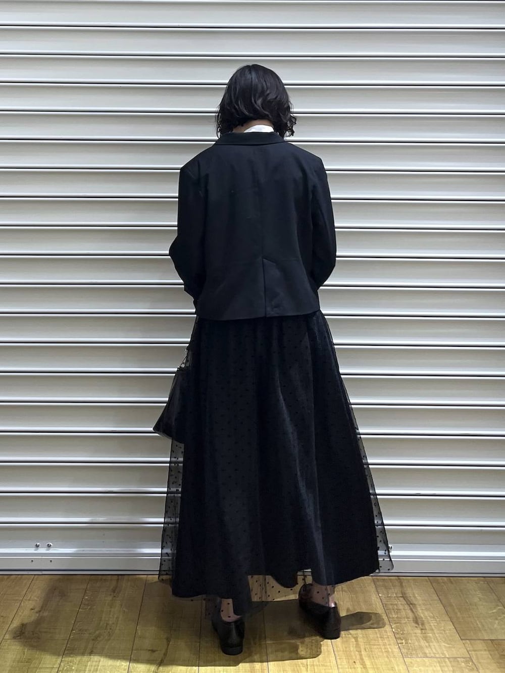 ブラック系のテーラードジャケット、ホワイト系のシャツ/ブラウス、ブラック系のスカートを着用したレディースの冬コーディネートの4枚目の写真