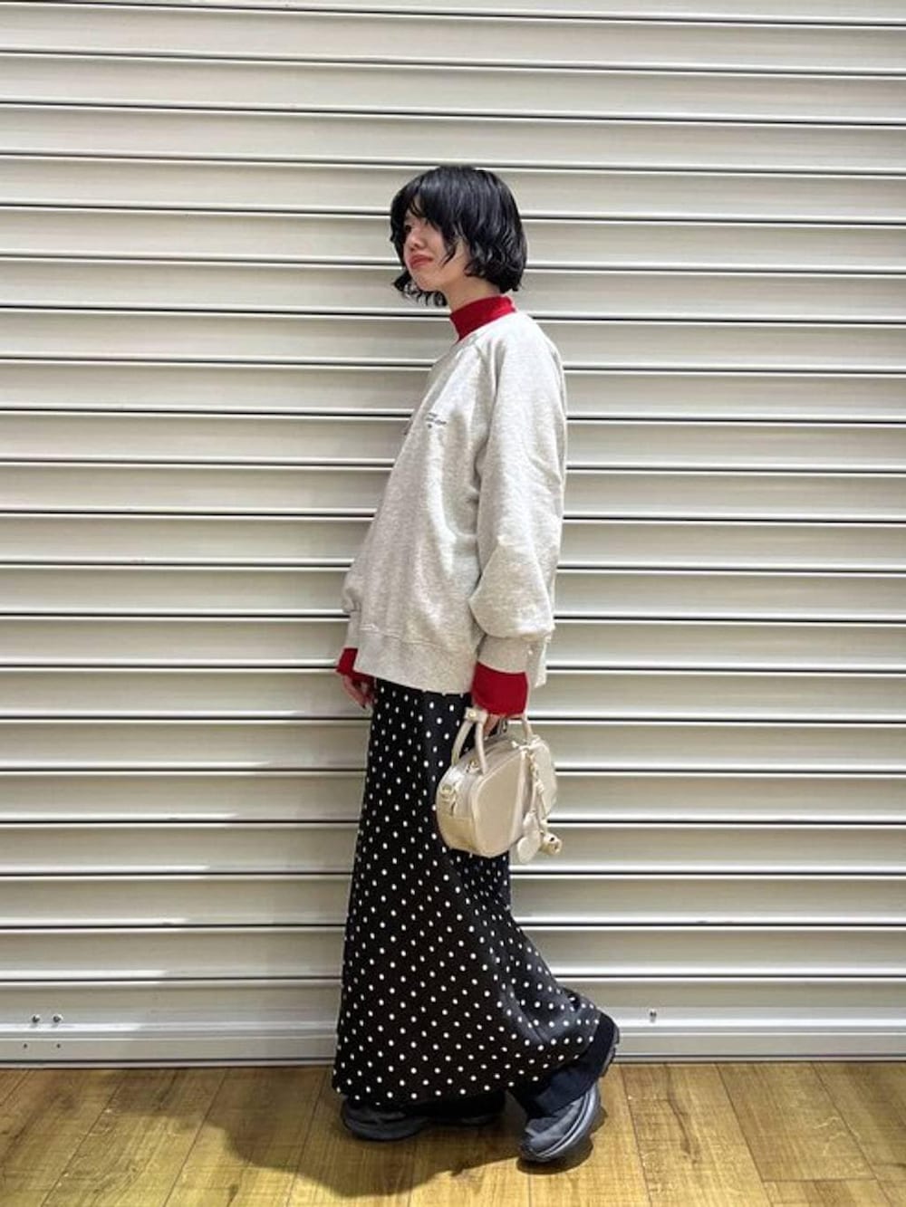 ホワイト系のスカート、レッド系のニット/セーター、ブラック系のその他パンツを着用したレディースの冬コーディネートの2枚目の写真