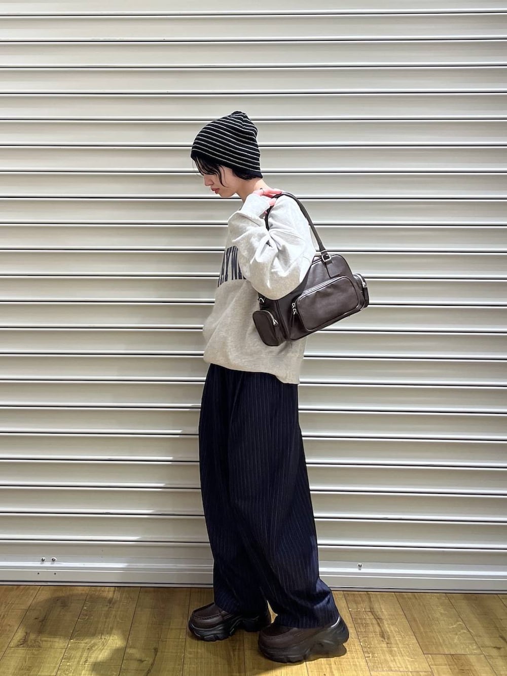 ブルー系のその他パンツ、ブラック系のボストンバッグ、ブラック系のローファーを着用したレディースの冬コーディネートの2枚目の写真