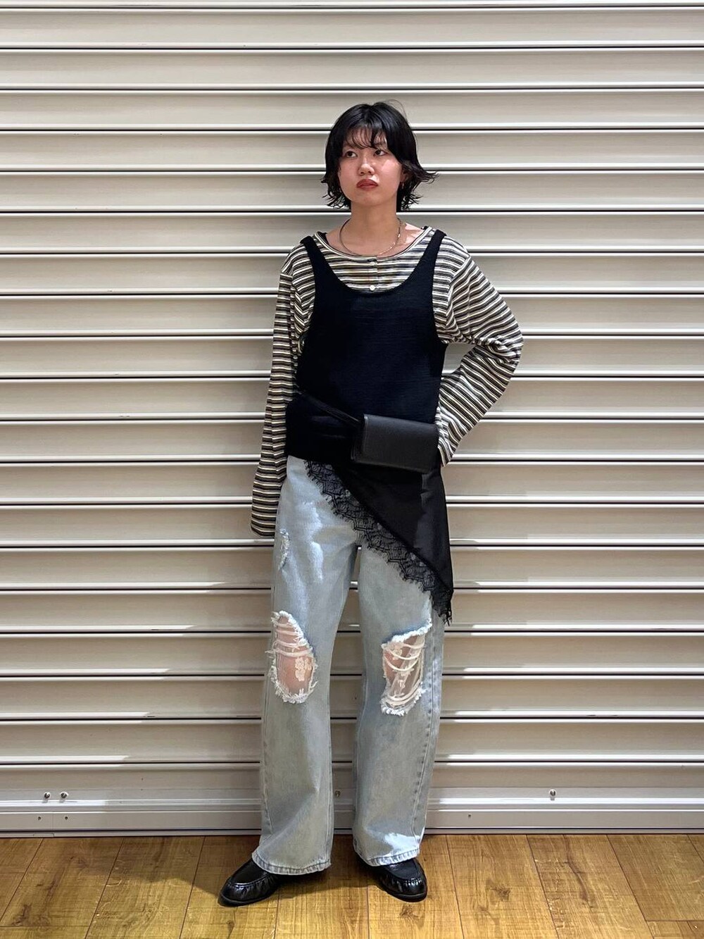 ブルー系のデニムパンツ、ブラック系のローファー、ブラウン系のボディバッグ/ウエストポーチを着用したレディースの春コーディネートの2枚目の写真