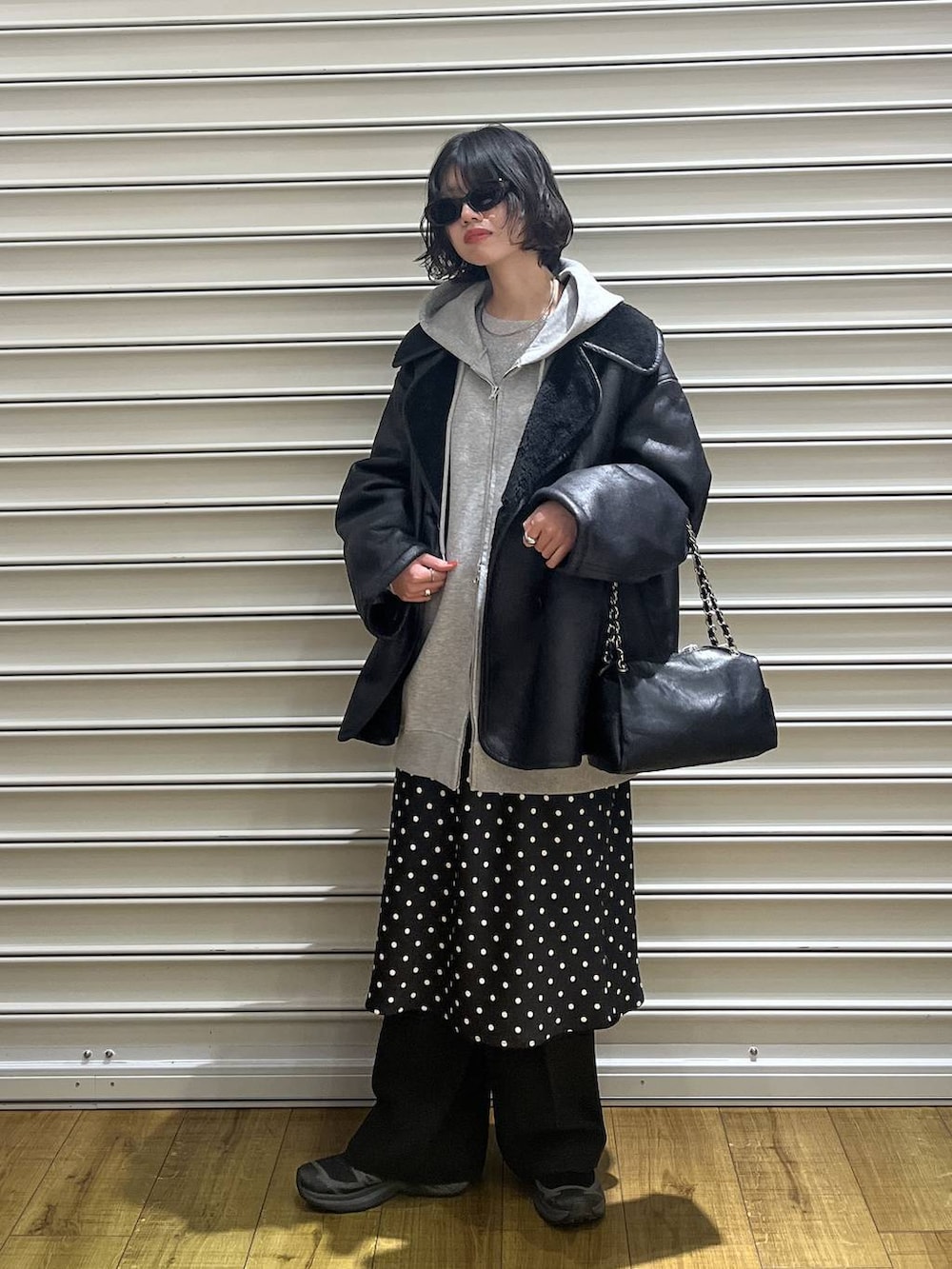 ブラック系のスカート、グレー系のパーカー、ブラック系のムートンコートを着用したレディースの冬コーディネートの4枚目の写真