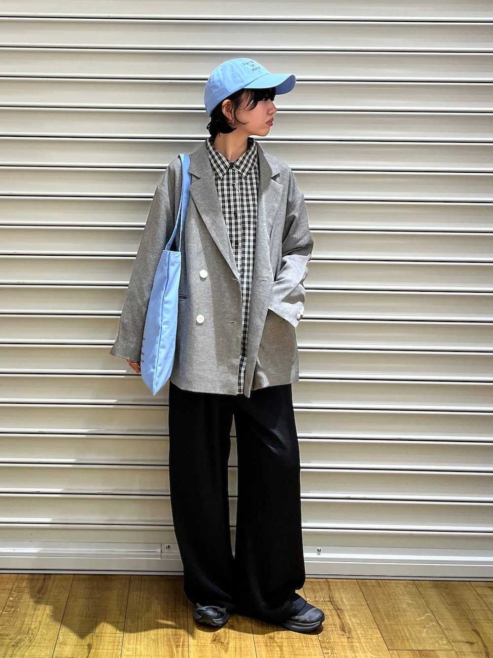 ブラック系のその他パンツ、グレー系のテーラードジャケット、ブルー系のトートバッグを着用したレディースの春コーディネートの2枚目の写真