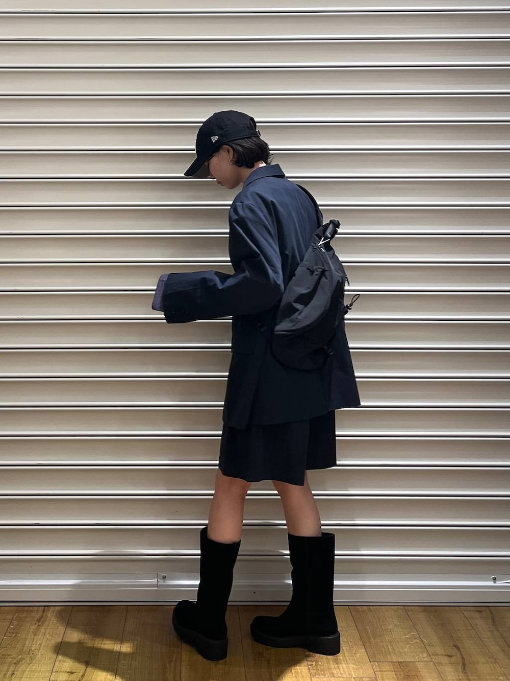 ブラック系のブーツ、ブラック系のショルダーバッグ、ブルー系のTシャツ/カットソーを着用したレディースの冬コーディネートの2枚目の写真