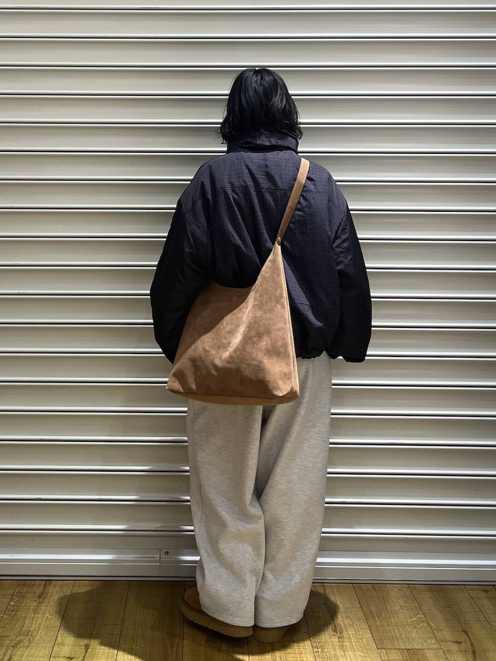 ベージュ系のショルダーバッグ、グレー系のスウェットパンツ、ベージュ系のブーツを着用したレディースの冬コーディネートの3枚目の写真