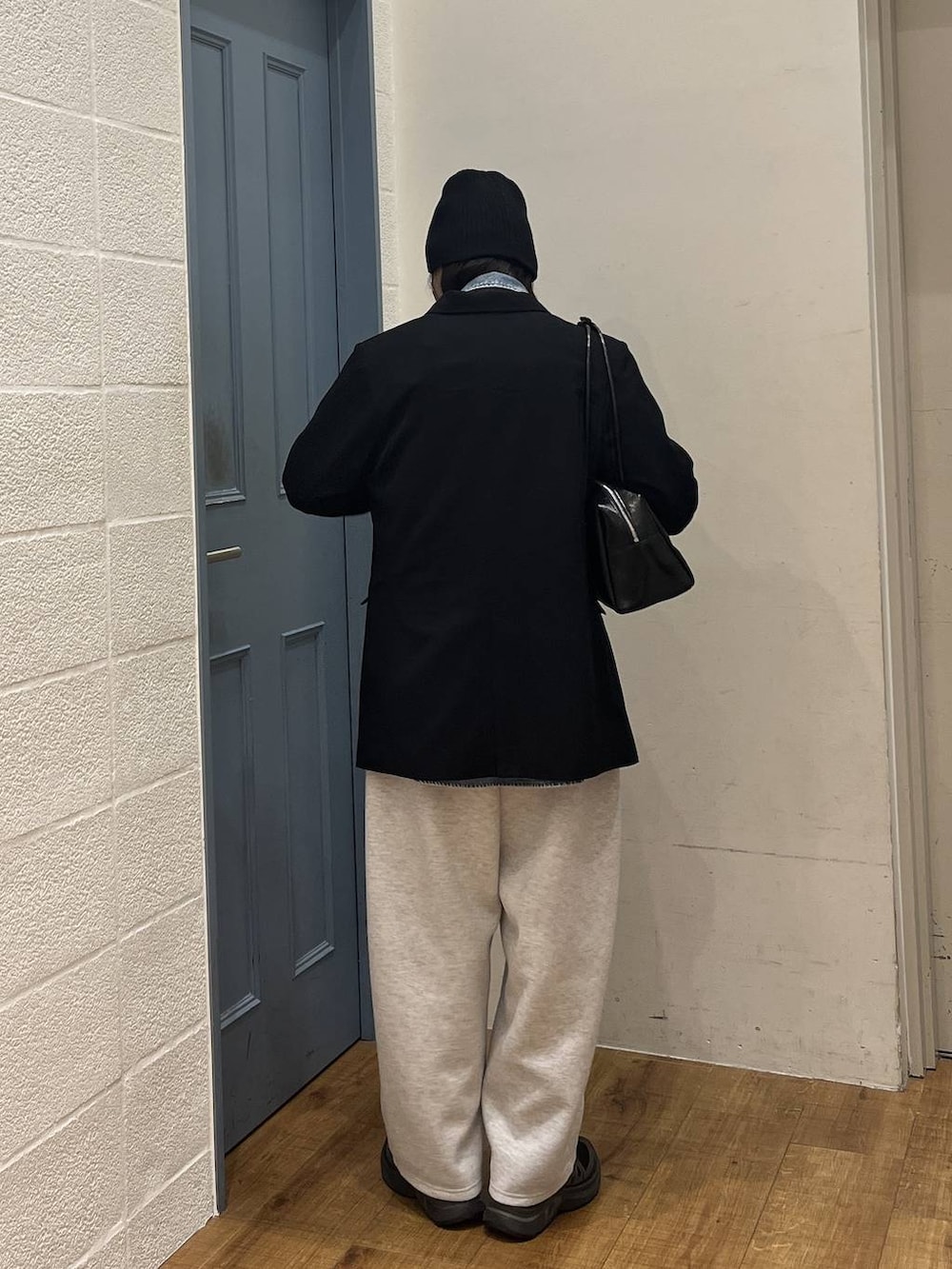 グレー系のスウェットパンツ、ブラック系のボストンバッグ、ブラック系のテーラードジャケットを着用したレディースの冬コーディネートの3枚目の写真