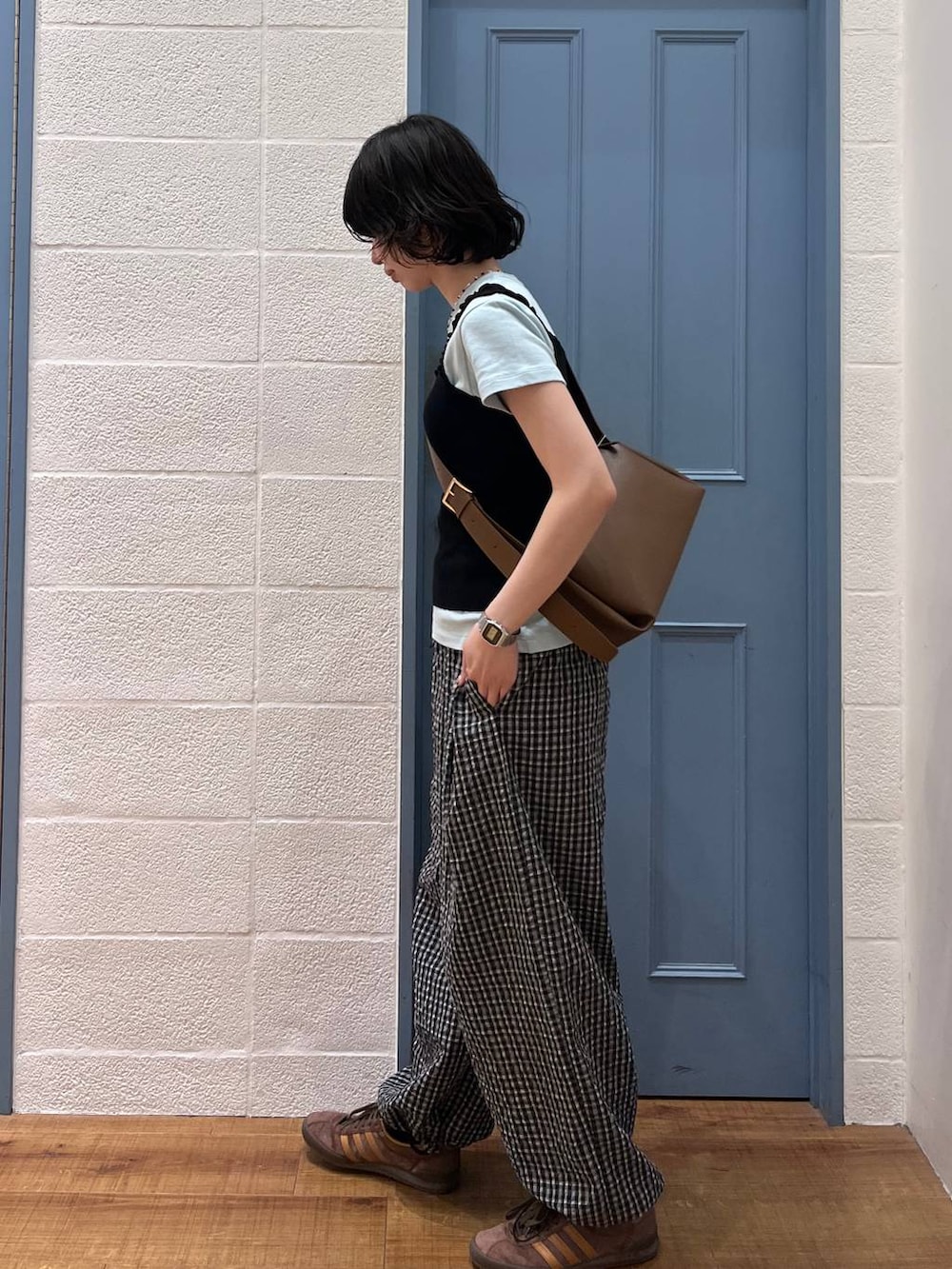 ブラック系のタンクトップ、ブラウン系のショルダーバッグ、ブルー系のTシャツ/カットソーを着用したレディースの春コーディネートの2枚目の写真