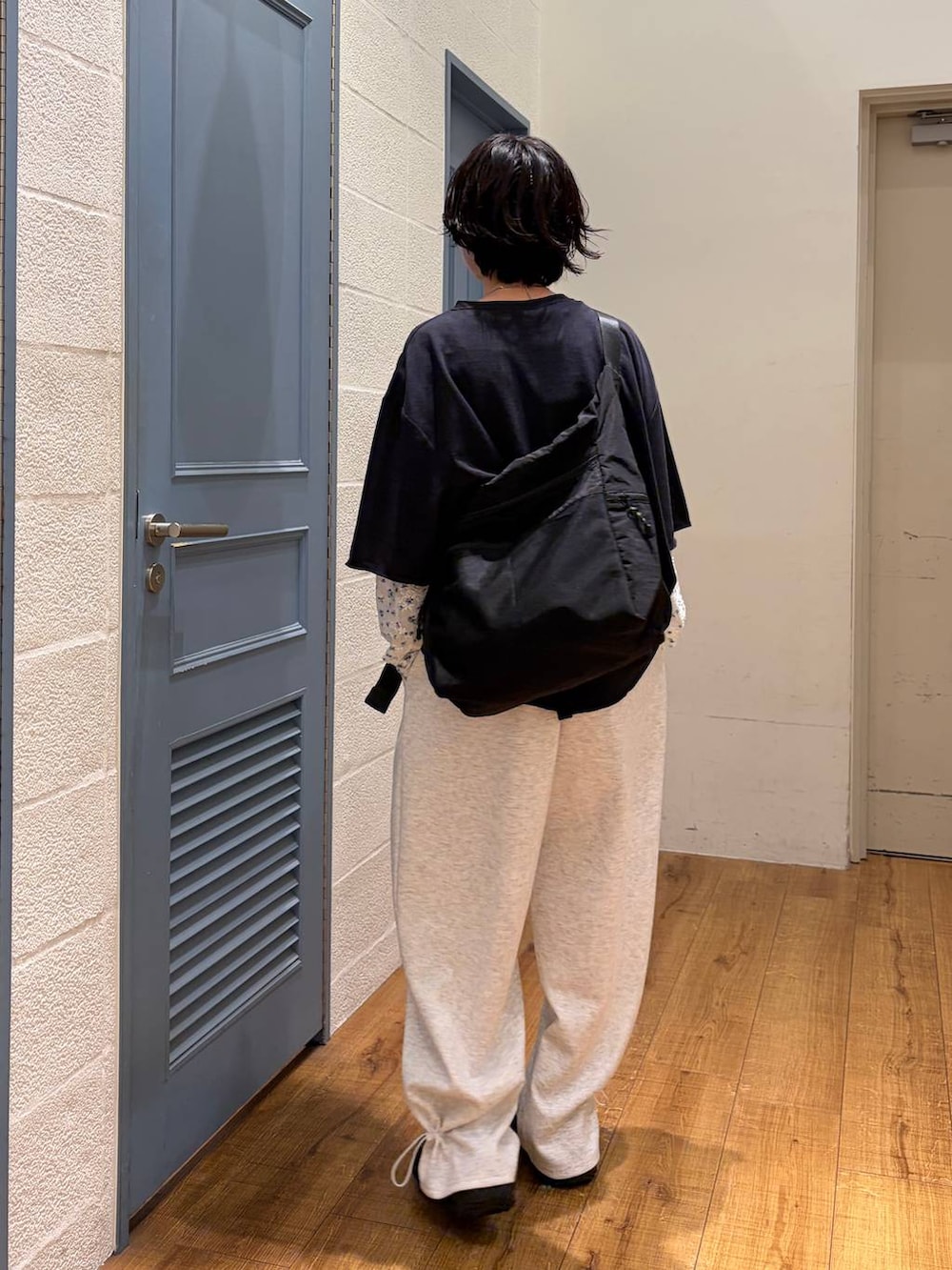 ブラック系のショルダーバッグ、グレー系のスウェットパンツ、ブラック系のTシャツ/カットソーを着用したレディースの夏コーディネートの2枚目の写真