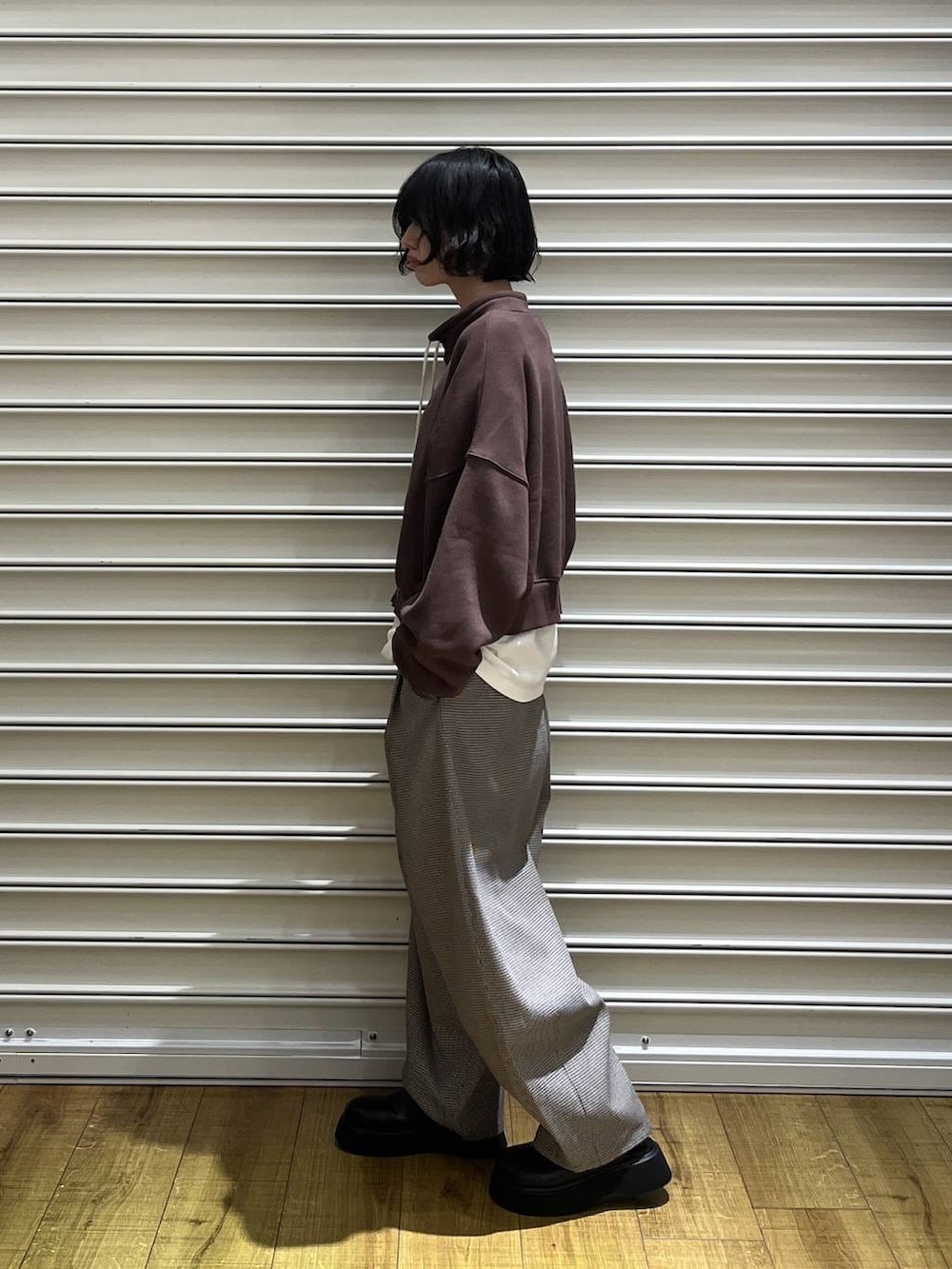 ブラック系のサンダル、ホワイト系のTシャツ/カットソー、ブラウン系のスウェットを着用したレディースの秋コーディネートの2枚目の写真