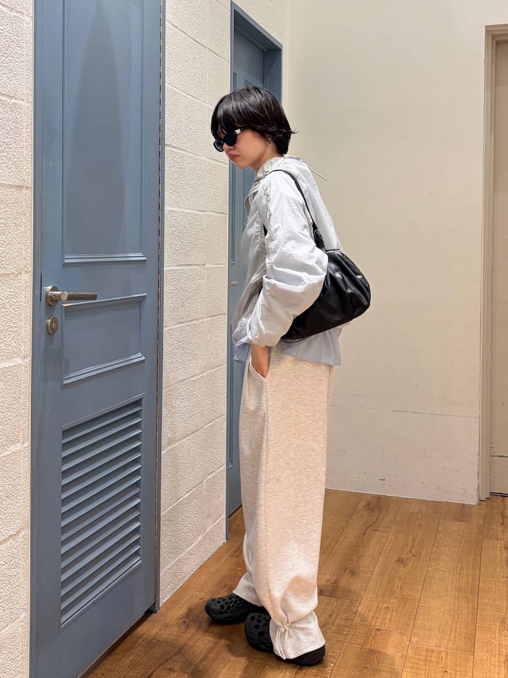 グレー系のスウェットパンツ、ブラック系のボストンバッグ、グレー系のカーディガン/ボレロを着用したレディースの夏コーディネートの2枚目の写真