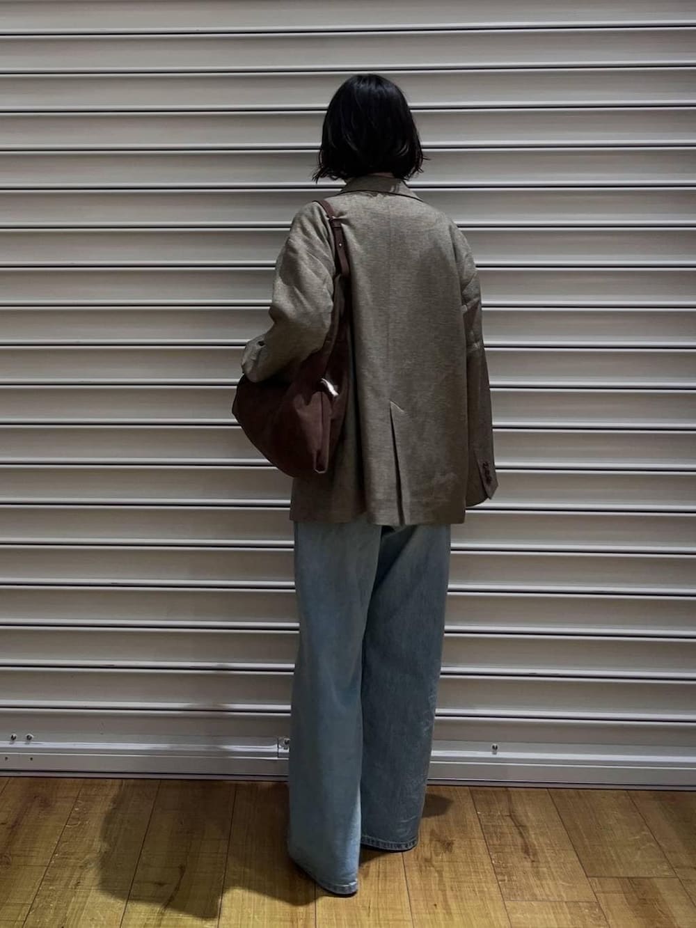 ブラウン系のテーラードジャケット、ブルー系のデニムパンツ、その他のパンプスを着用したレディースの冬コーディネートの4枚目の写真