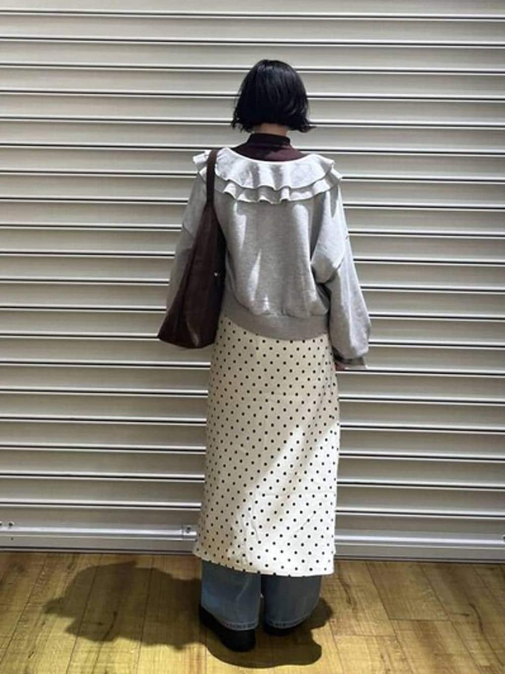 ブラウン系のショルダーバッグ、ホワイト系のスカート、ブラウン系のニット/セーターを着用したレディースの冬コーディネートの3枚目の写真