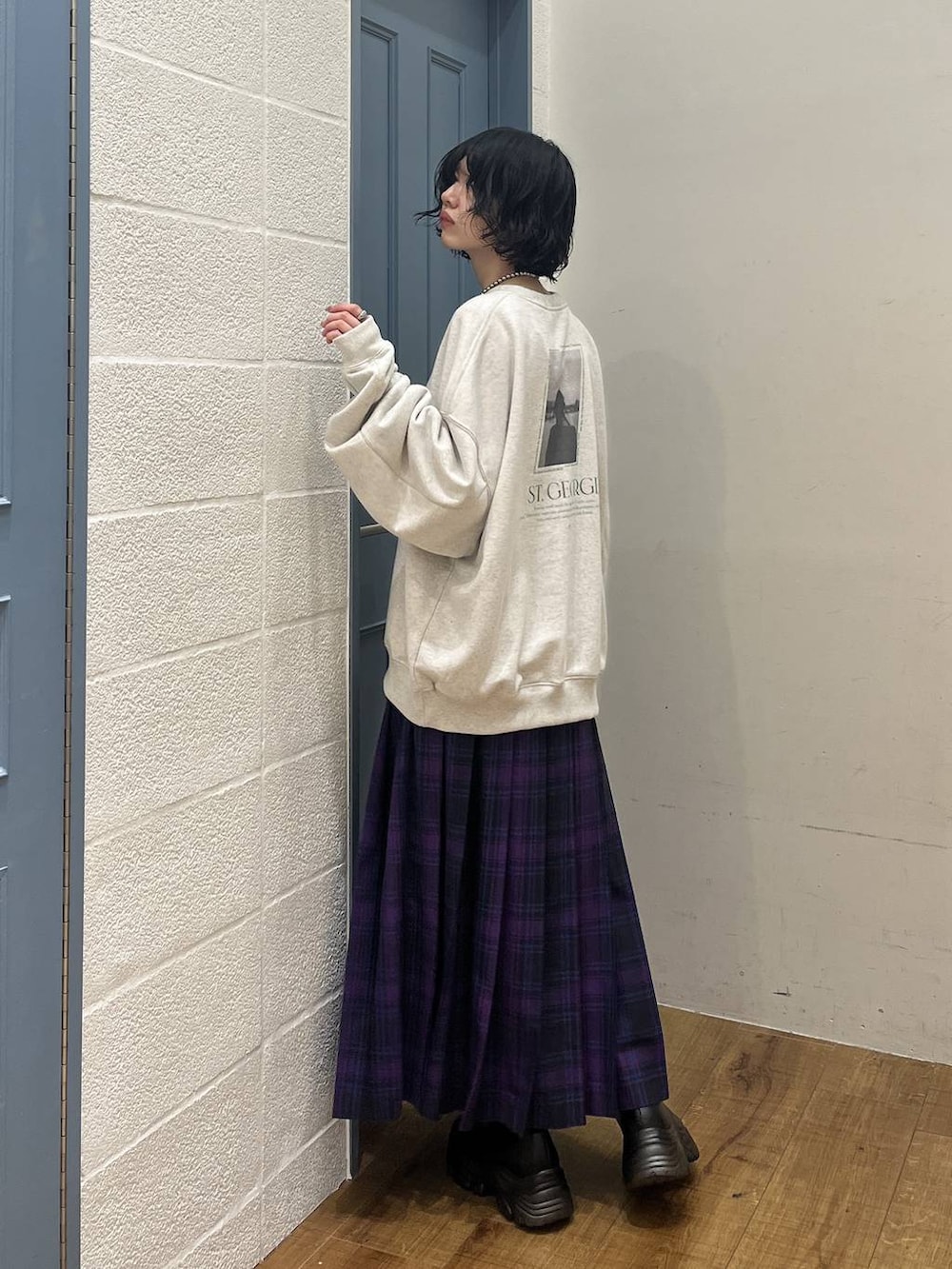 ブラック系のブーツ、パープル系のスカート、グレー系のスウェットを着用したレディースの冬コーディネートの2枚目の写真