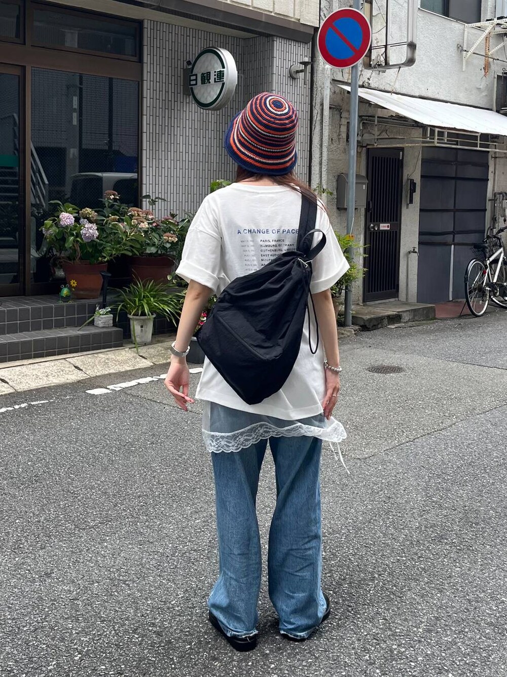 ホワイト系のTシャツ/カットソー、ブラック系のショルダーバッグ、ブラック系のスニーカーを着用したレディースの夏コーディネートの2枚目の写真
