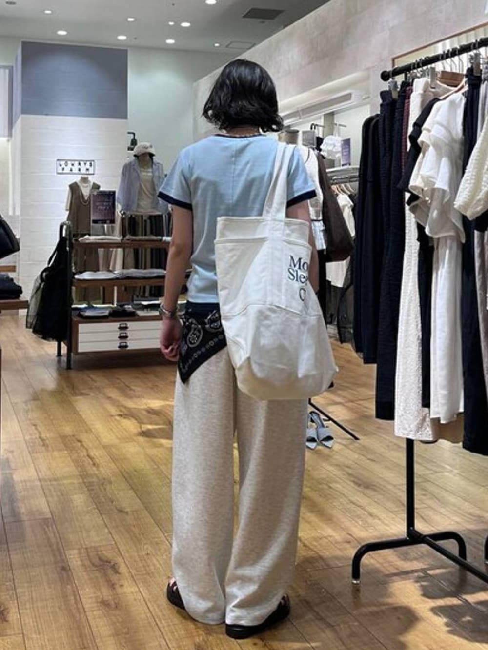 グレー系のスウェットパンツ、ブラウン系のサンダル、ホワイト系のトートバッグを着用したレディースの夏コーディネートの3枚目の写真