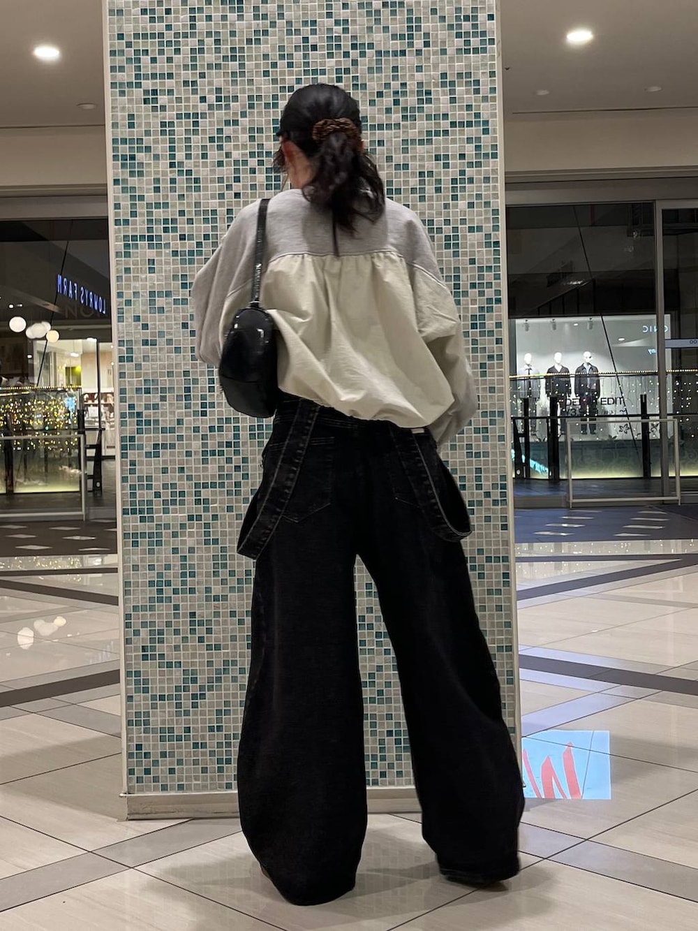 ブラック系のデニムパンツ、ブラック系のトートバッグ、グレー系のスウェットを着用したレディースの春コーディネートの4枚目の写真