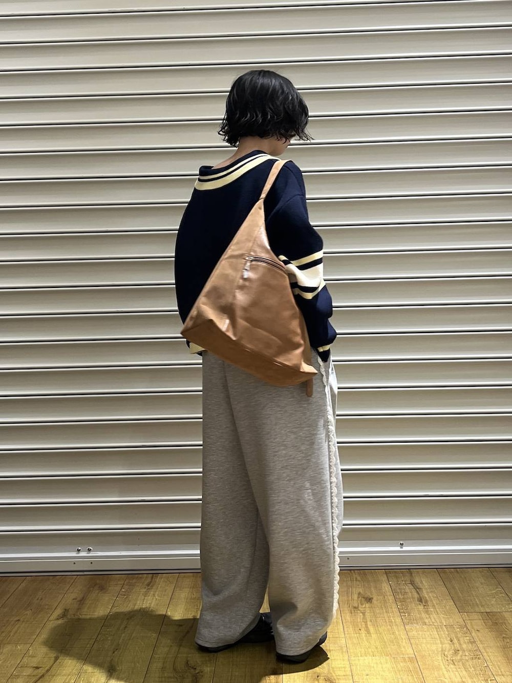 ベージュ系のショルダーバッグ、グレー系のスウェットパンツ、ブルー系のニット/セーターを着用したレディースの冬コーディネートの3枚目の写真