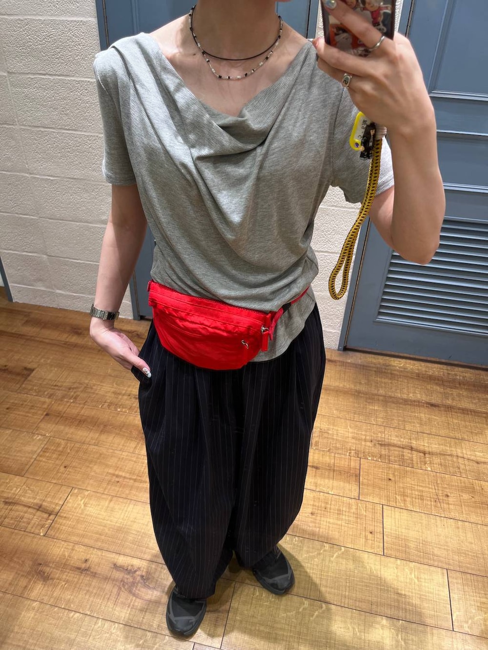 ブルー系のその他パンツ、レッド系のボディバッグ/ウエストポーチ、グレー系のTシャツ/カットソーを着用したレディースの春コーディネートの2枚目の写真