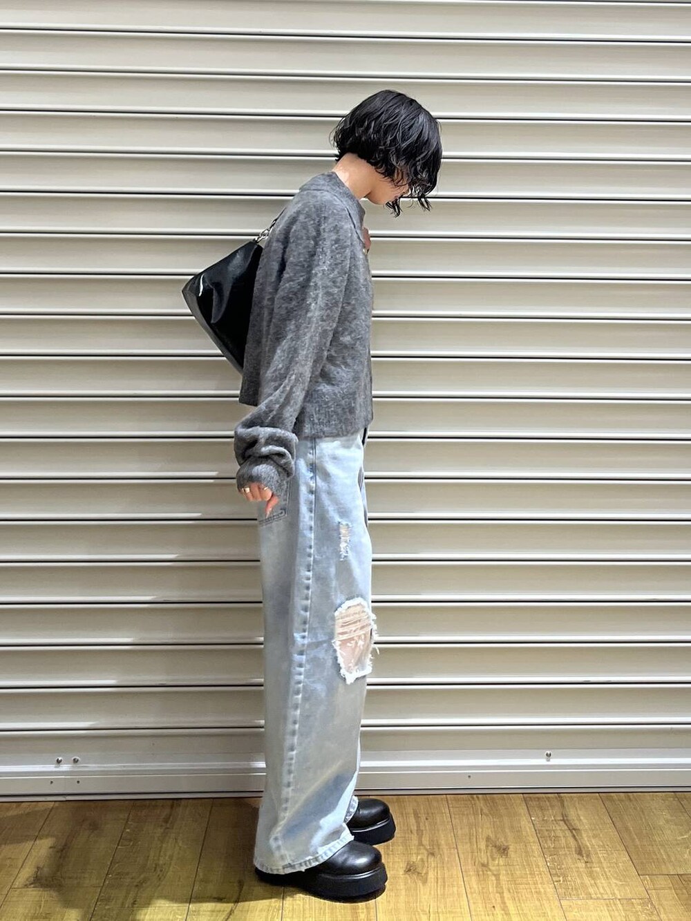 ブラック系のサンダル、グレー系のニット/セーター、ブルー系のデニムパンツを着用したレディースの冬コーディネートの2枚目の写真