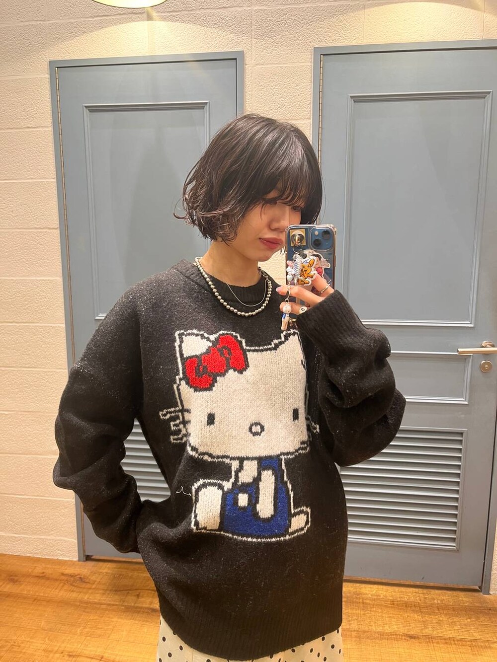 ホワイト系のスカート、ブルー系のデニムパンツ、ブラック系のニット/セーターを着用したレディースの秋コーディネートの4枚目の写真