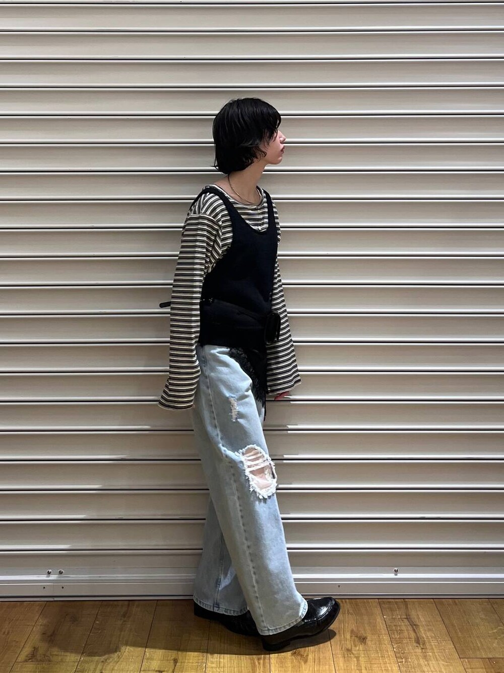 ブルー系のデニムパンツ、ブラック系のローファー、ブラウン系のボディバッグ/ウエストポーチを着用したレディースの春コーディネートの3枚目の写真