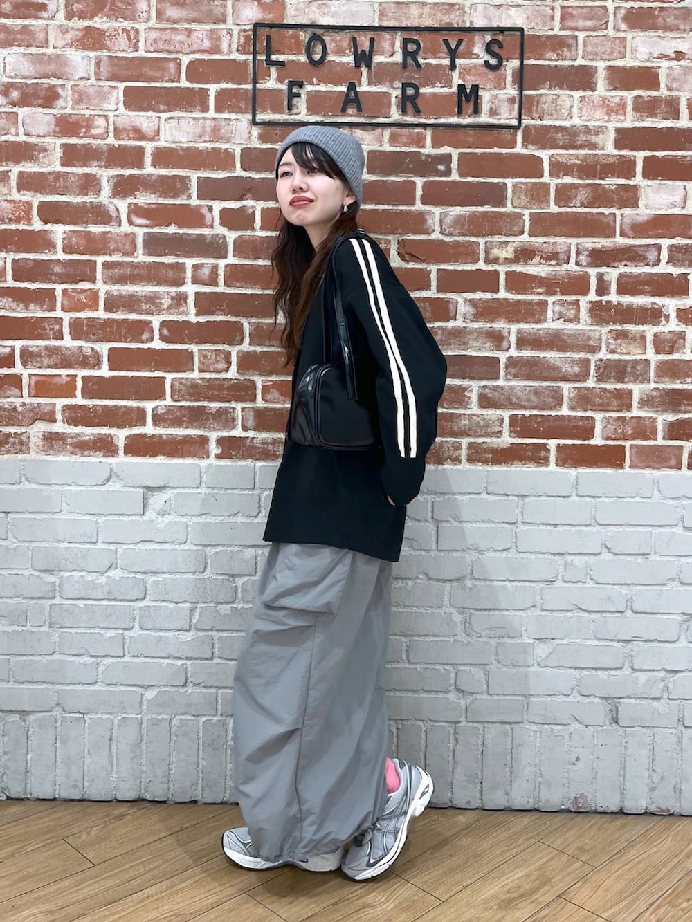 ブラック系のハンドバッグ、グレー系のスカート、ブラック系のカーディガン/ボレロを着用したレディースの春コーディネートの2枚目の写真