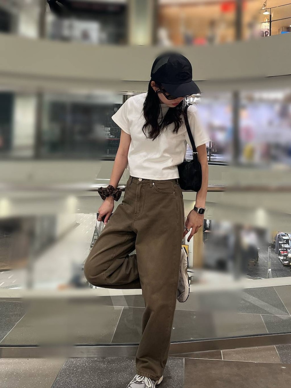 ホワイト系のTシャツ/カットソー、ブラック系のトートバッグ、ブラウン系のデニムパンツを着用したレディースの春コーディネートの3枚目の写真