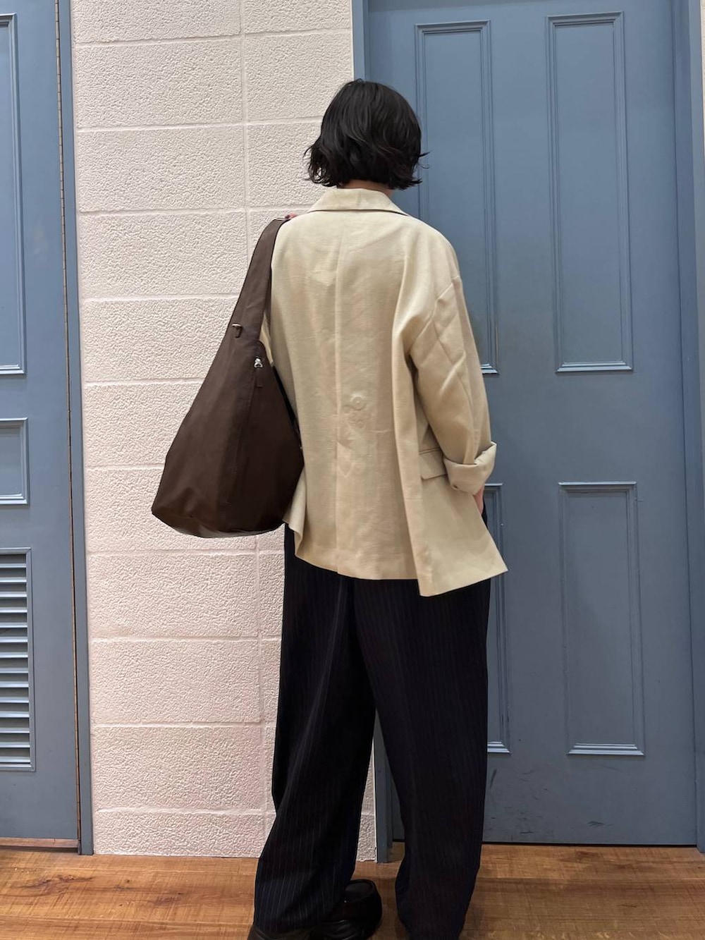 ブルー系のその他パンツ、ベージュ系のその他アウター、ブラウン系のショルダーバッグを着用したレディースの春コーディネートの4枚目の写真