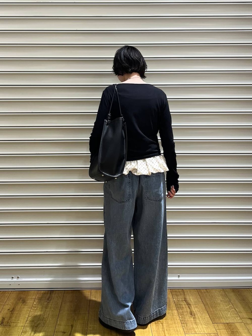 ブルー系のデニムパンツ、ブラック系のサンダル、グレー系のTシャツ/カットソーを着用したレディースの春コーディネートの4枚目の写真